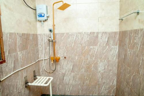 a shower with a bench in a bathroom at Royce's Apartment in Kigali