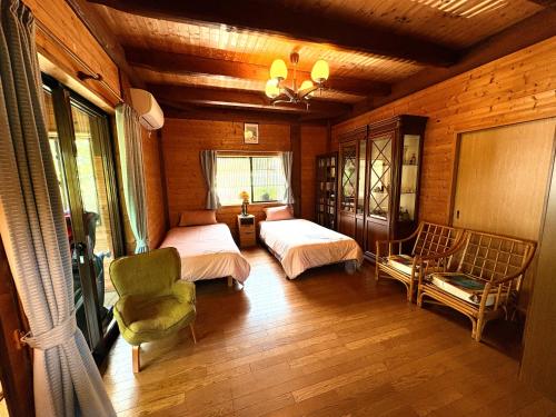 a bedroom with two beds and a chair at beau lac biwako in Takashima