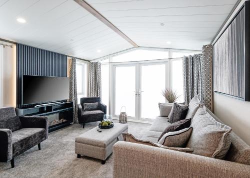 a living room with a couch and a tv at Monarch Lakes in Boston