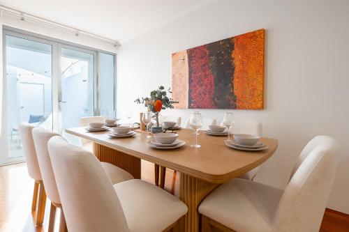 a dining room table with white chairs and a painting at Family Friendly, Stylish Floreat, Pool in Perth