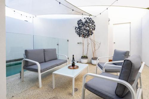 a living room with two chairs and a table at Family Friendly, Stylish Floreat, Pool in Perth