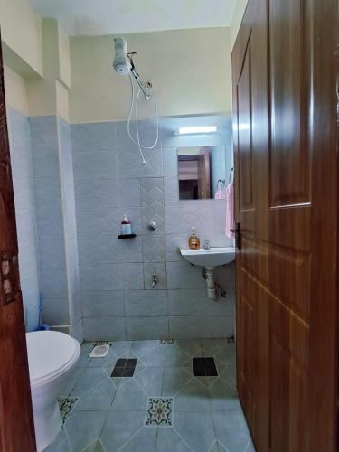 a bathroom with a shower and a toilet and a sink at Nesty Homes in Gitura