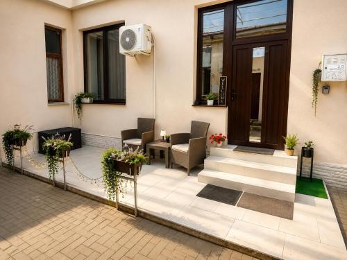 a porch of a house with chairs and a door at Mid Ultra Central Apartments, Self Check In in Oradea