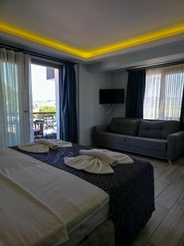 a bedroom with a large bed and a couch at Ada Marin Hotel in Urla