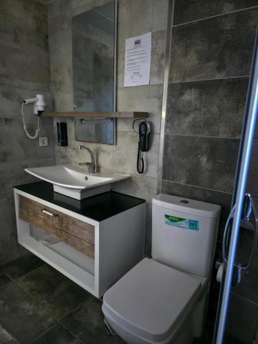a bathroom with a sink and a toilet and a phone at Ada Marin Hotel in Urla