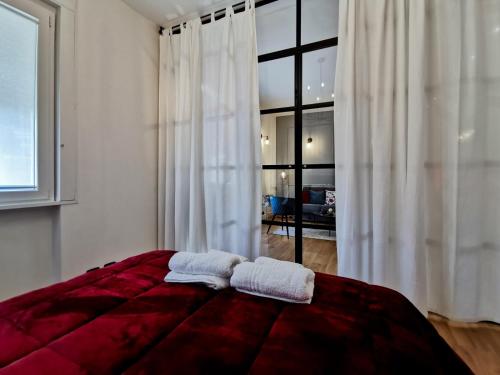 a bedroom with a red bed with two towels on it at FLORENTIN Downtown Design Apt in Bergamo