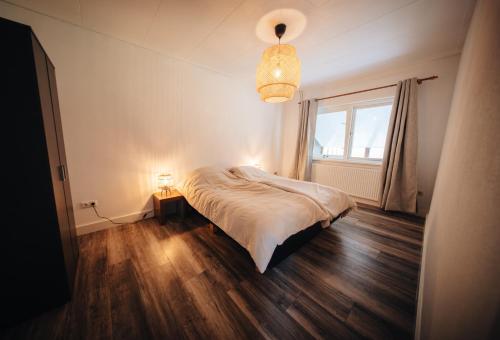 a bedroom with a bed and a window and a lamp at Natuurhuisje 'n Snuffelstee in Markelo
