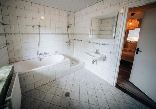 a bathroom with a tub and a sink at Natuurhuisje 'n Snuffelstee in Markelo