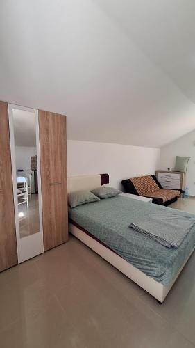 a bedroom with a large bed and a mirror at Coco free parking in Pržno