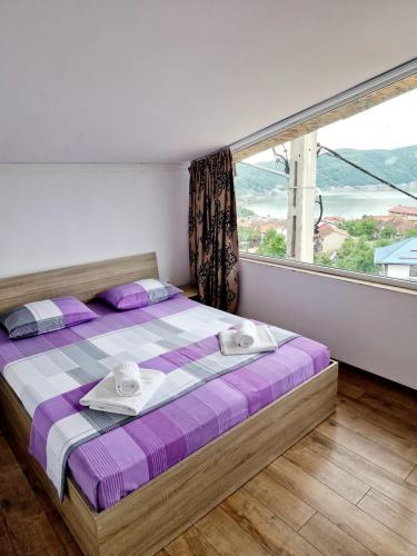 a bedroom with a bed with a large window at Casa Elvina in Dubova