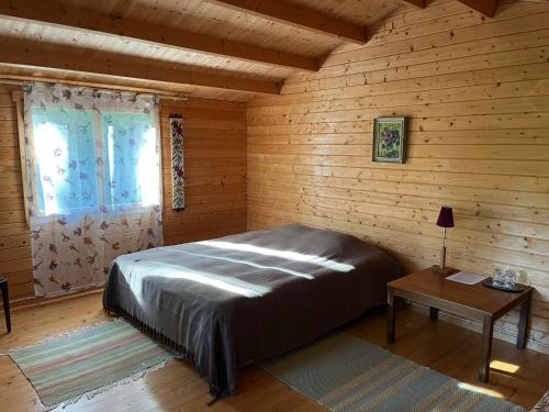 a bedroom with a bed in a wooden room at Voosemetsa Turismitalu in Voose