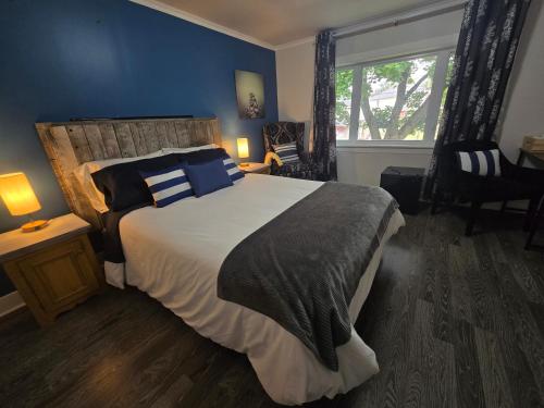 a bedroom with a large bed with blue walls at Rester Vivant Chambres d'hôtes in Saint-Jean-Port-Joli