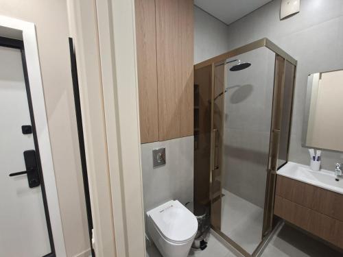 a small bathroom with a toilet and a shower at Central Avenue in Karagandy