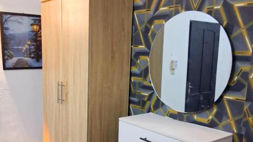 a bathroom with a sink and a mirror on a wall at Cotonou AMAZONE GUEST in Cotonou