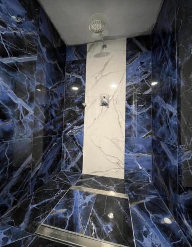 a bathroom with blue marble walls and a shower at Il Bunker in Bolano