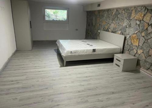a bedroom with a bed and a stone wall at Il Bunker in Bolano