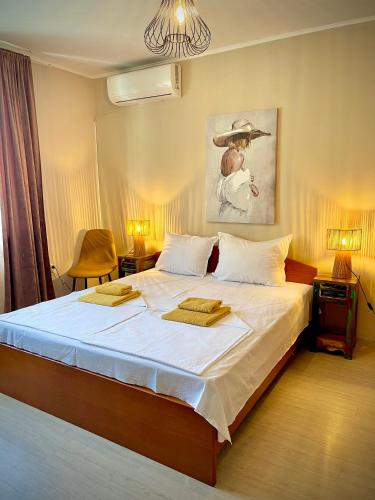 a bedroom with a large bed with two towels on it at Dimitrovi Guesthouse - Peaceful Stay near Beach with Garden, Sarafovo in Burgas