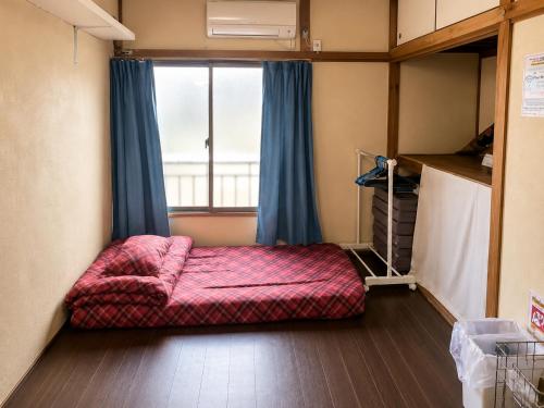 a small room with a bed and a window at Artist's Studio in Mitaka