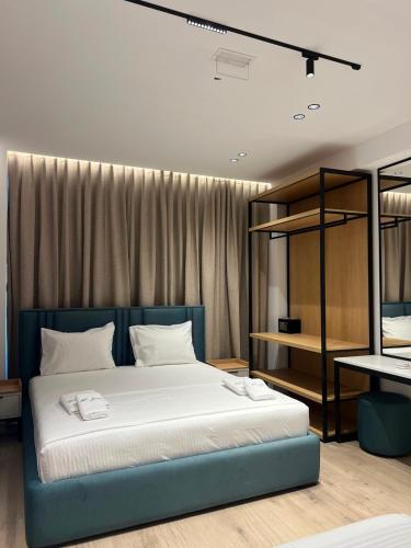 a bedroom with a large bed with white sheets at Blue Waves Hotel & Suites in Sarandë