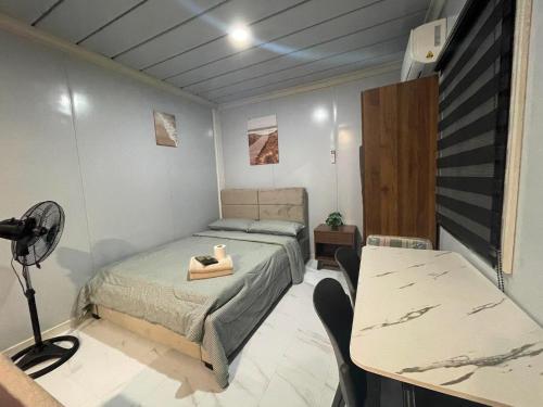 a bedroom with a bed and a desk and a table at Kecai Haven Transient House in Digos