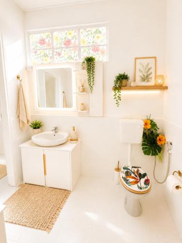a white bathroom with a sink and a mirror at Cocoon Signature in Flic-en-Flac
