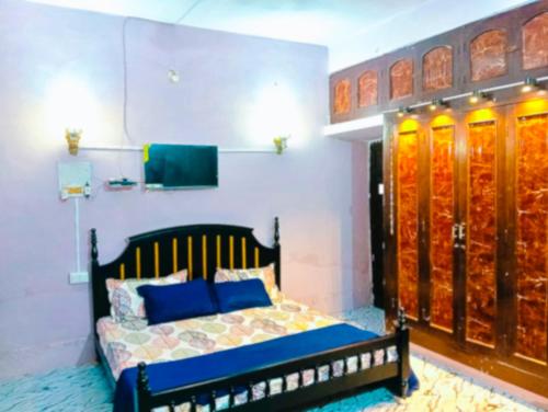 a bedroom with a bed with blue pillows at Shukla home stay in Jabalpur