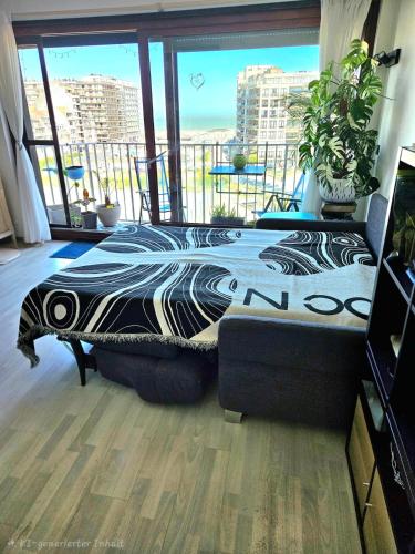 a bedroom with a bed in front of a large window at Modern Studio with Sea View and Balcony in Middelkerke