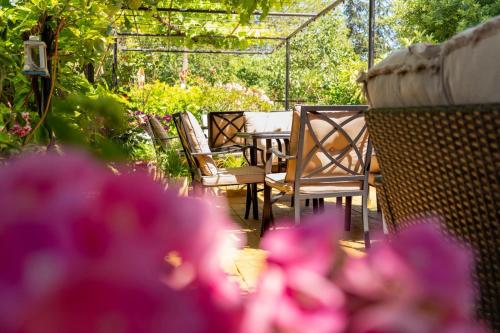 a table and chairs in a garden with pink flowers at Amirov Garden - Free parking & Free beach area in Kranevo