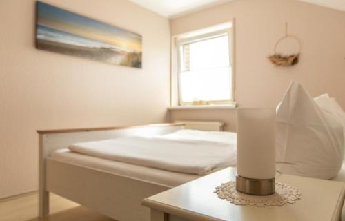 a bedroom with a bed and a table with a lamp at Ferienwohnung Doria in Windeck