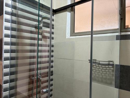a shower with a glass door in a bathroom at Neoclassical apartment downtown in Casablanca
