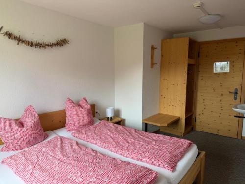 two beds in a room with pink pillows at Stöcki-Grindelwaldblick in Kleine Scheidegg