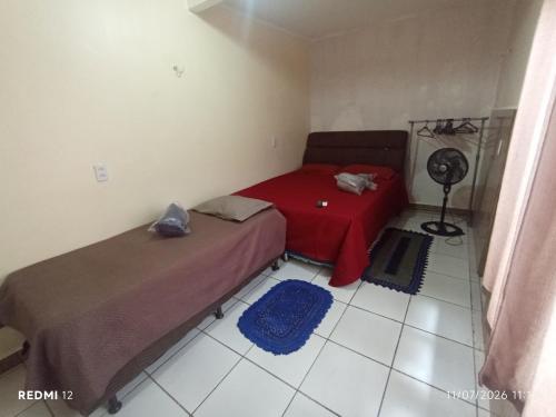 a bedroom with two beds and a fan on the floor at kit Net no Vinhais in São Luís