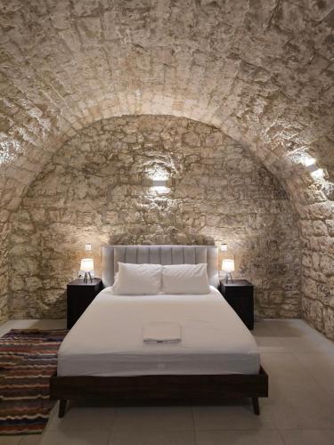 a bedroom with a bed in a stone wall at Estia Mylona in Ayios Therapon