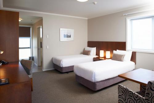 Habitación de hotel con 2 camas y escritorio en Argent Motor Lodge, en Hamilton