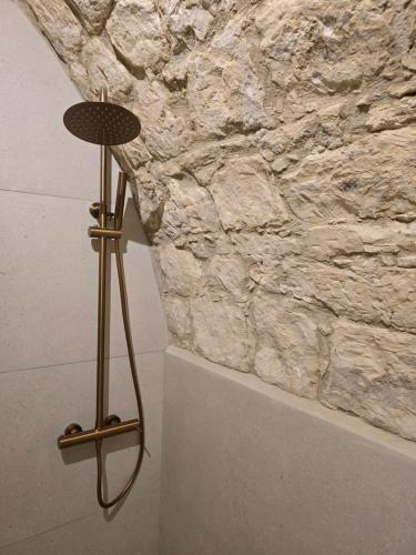 a lamp in front of a stone wall at Estia Mylona in Ayios Therapon