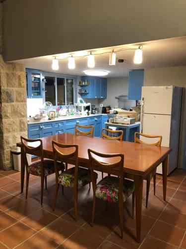 a kitchen with a wooden table and chairs and blue cabinets at Dar el Maasser دار المعاصر in Maasser El Chouf