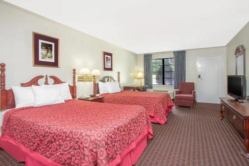 a hotel room with two beds and a television at A Red Dot Inn in Milledgeville