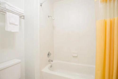 a white bathroom with a shower and a white toilet at A Red Dot Inn in Milledgeville