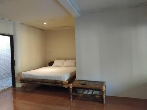 a bedroom with a bed and a table at MBE BALENG KU in Mangsit