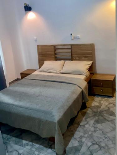 a bedroom with a bed and two night stands at Velo Apartments in Kribi in Kribi