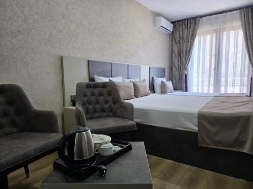 a hotel room with a bed and two chairs at Real Hotel Van in Ipekyolu