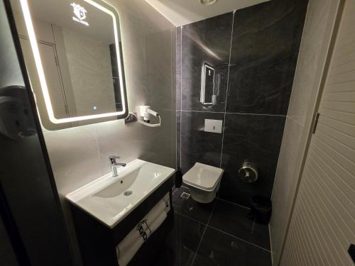 a bathroom with a sink and a toilet and a mirror at Real Hotel Van in Ipekyolu
