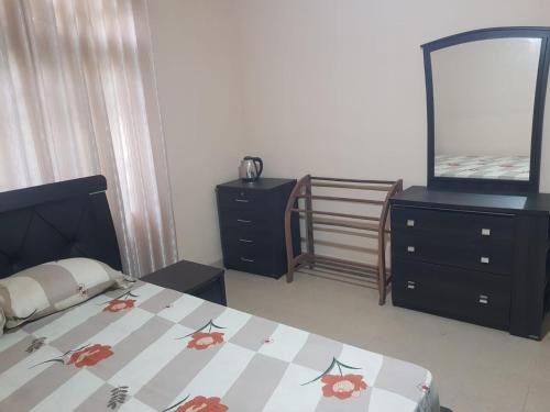 a bedroom with a bed and a dresser and a mirror at Calm Cottege in Gampaha