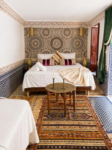 a bedroom with a bed and a table at Riad Fes Colors & SPA - Family Lodging in Fez