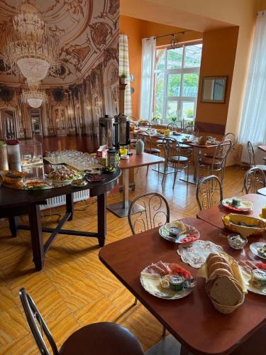 a dining room with tables and chairs with food on them at Arkadia - Amber in Jantar
