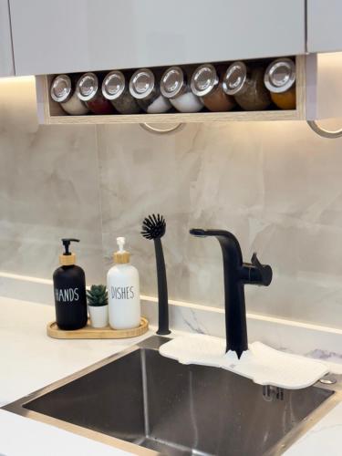 a kitchen sink with a black faucet and a counter at Riviera garden 9 in Cabo Negro