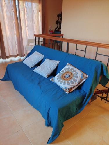 a blue bed with two pillows on top of it at Lacaz Vacances in Tamarin