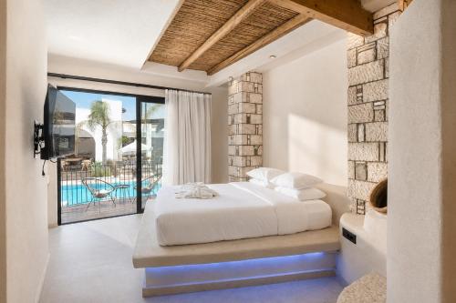a bedroom with a bed and a balcony with a pool at Kouros Home & Suites--Faliraki--Adults Only in Faliraki