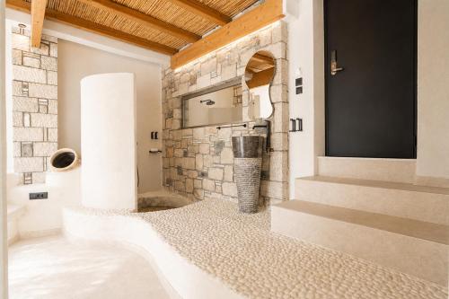 a room with a stone fireplace and a television at Kouros Home & Suites--Faliraki--Adults Only in Faliraki