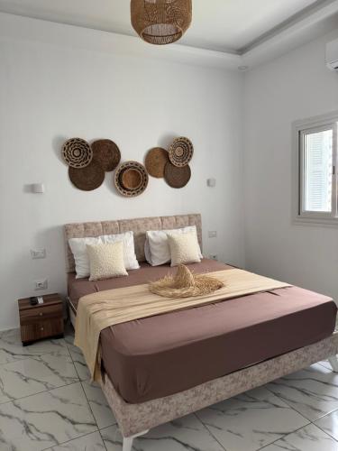 a bedroom with a large bed with hats on the wall at Villa Mazzyd in Temlale